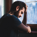 depressed man by window