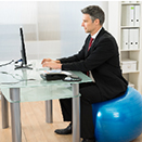 Man sitting at desk on an exercise ball