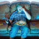 Child sitting on couch eating junk food