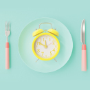 clock on plate with fork and knife