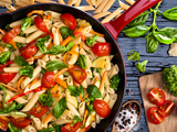 Pasta dish with tomatoes and seasonings in pan