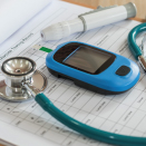 glucometer and stethoscope on clipboard