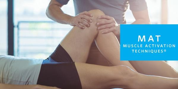 Muscle Activation Techniques - trainer applying pressure to client's knee with his hands