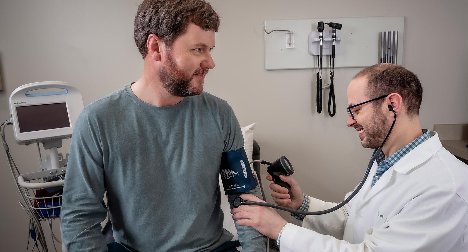 Cooper doctor giving a blood pressure test to patient