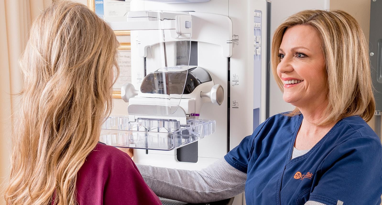 Senior woman having mammography scan at hospital with medical technician