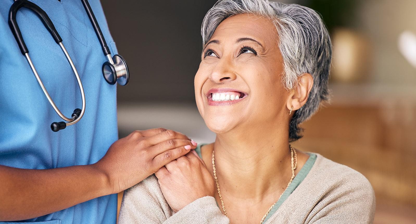 Nurse, senior woman and smile with comfort, holding hands or support