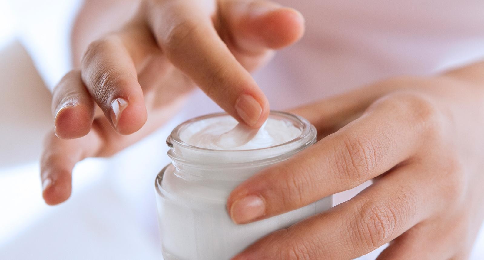 woman's hand touching on the cream for applying