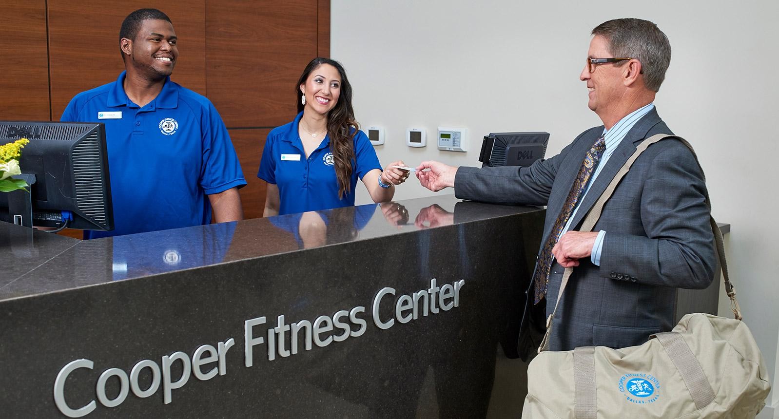 Someone checking in to the Cooper Fitness Center front desk
