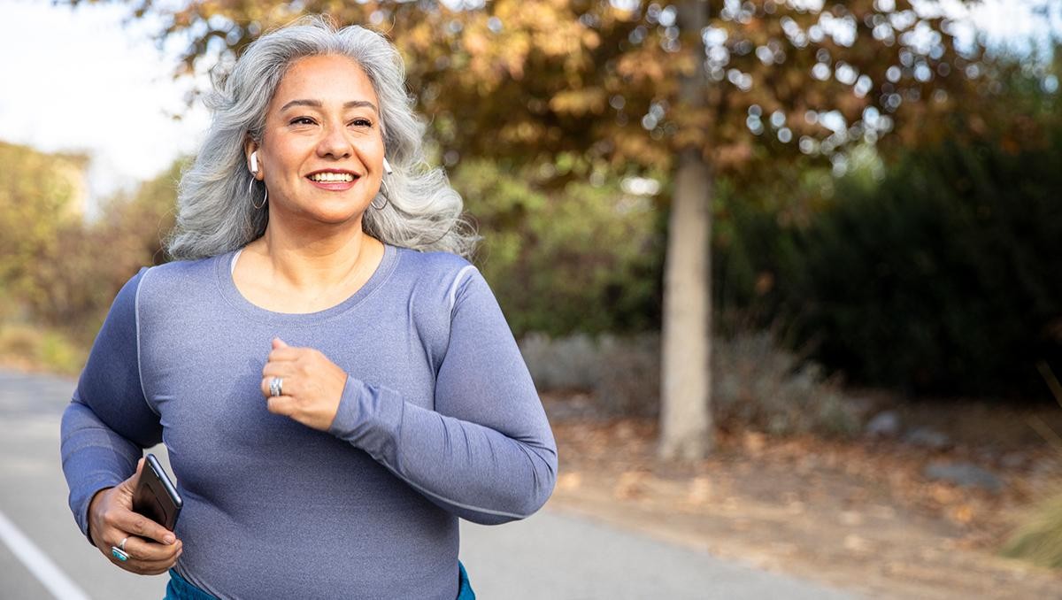 A mature Mexican woman jogging on a trail