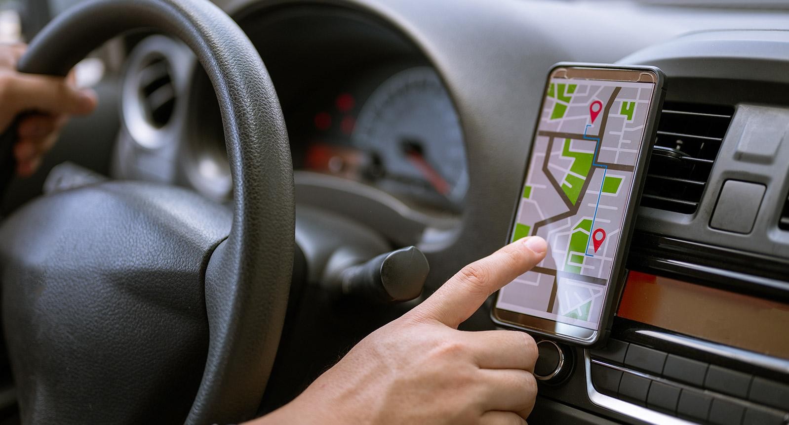 Driver uses navigation on his mobile phone in the car