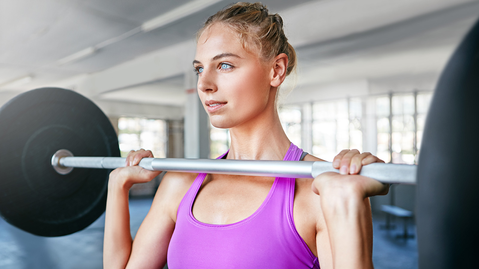 Shot of a young woman working out with weights at the gym