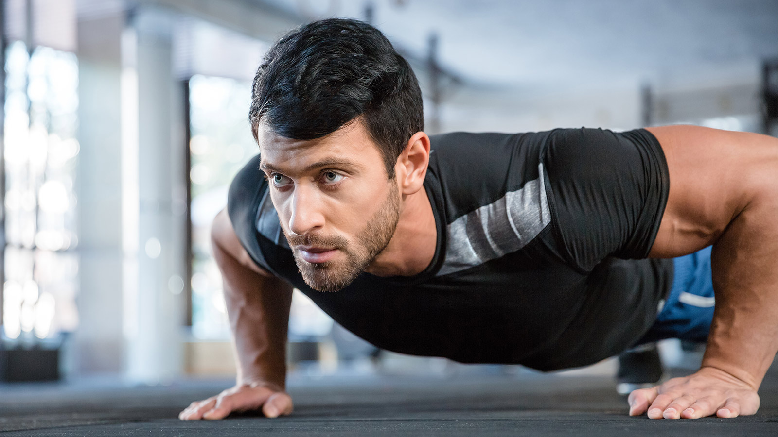 Portrait of a fitness man doing push ups in gym