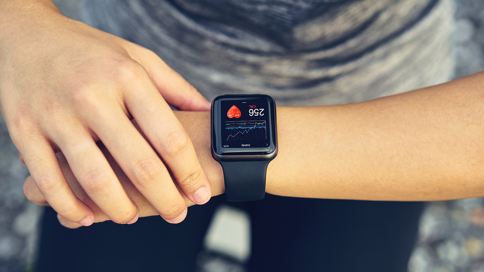 Young woman checking the sports watch measuring heart rate and performance after running.