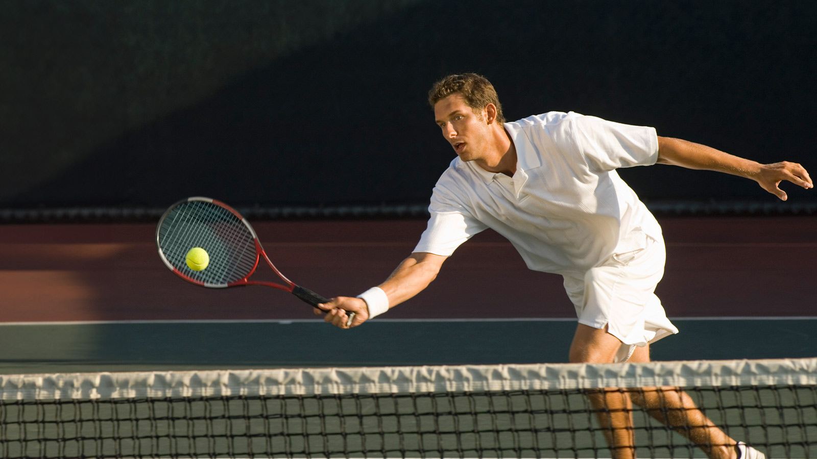 Tennis Player Swinging at Ball