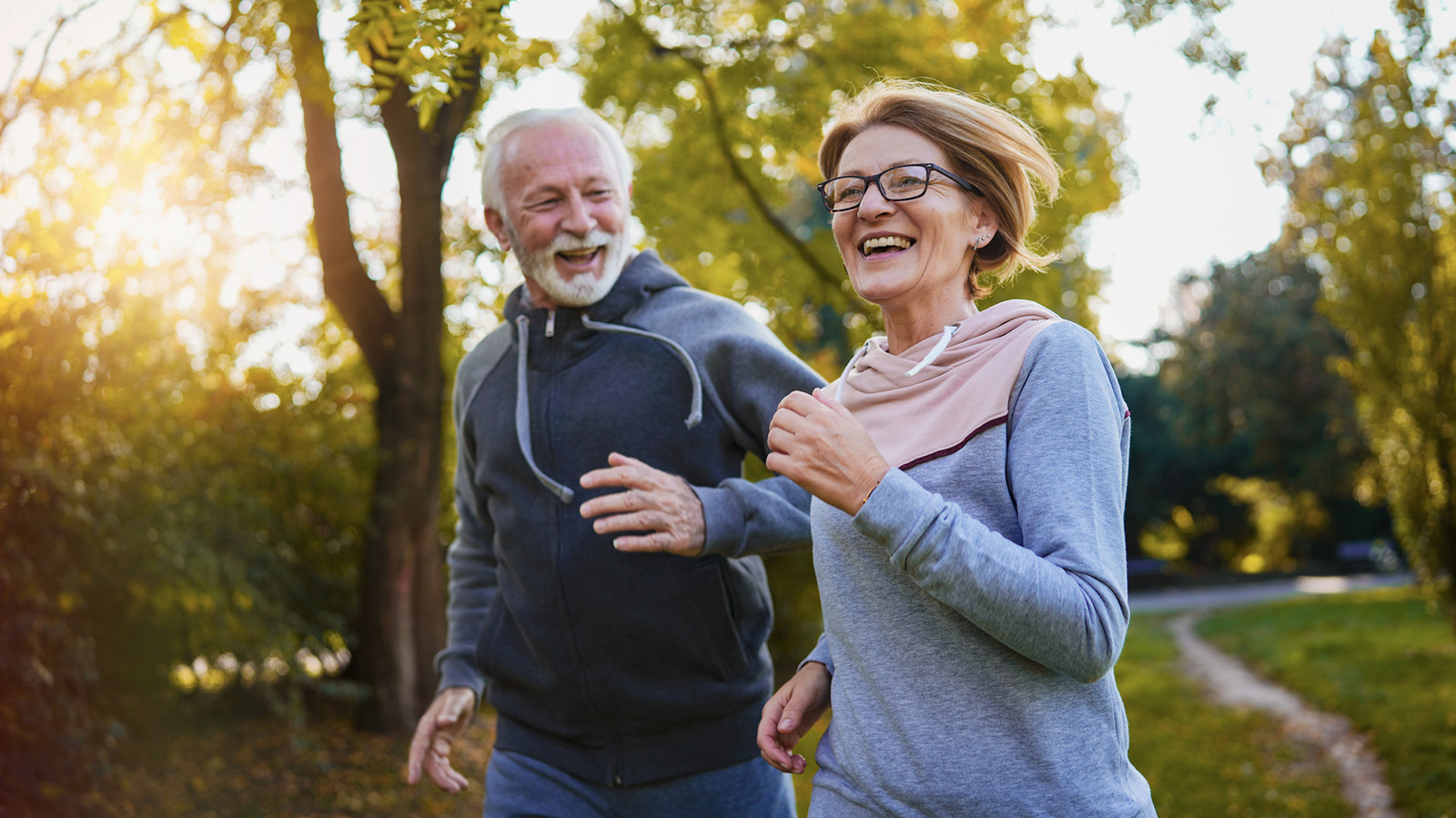 Older couple running on a path outside