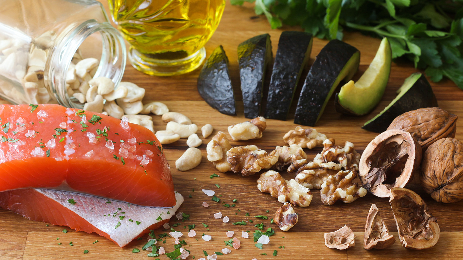 Cutting board full of food like salmon and pecans that can help with inflammation
