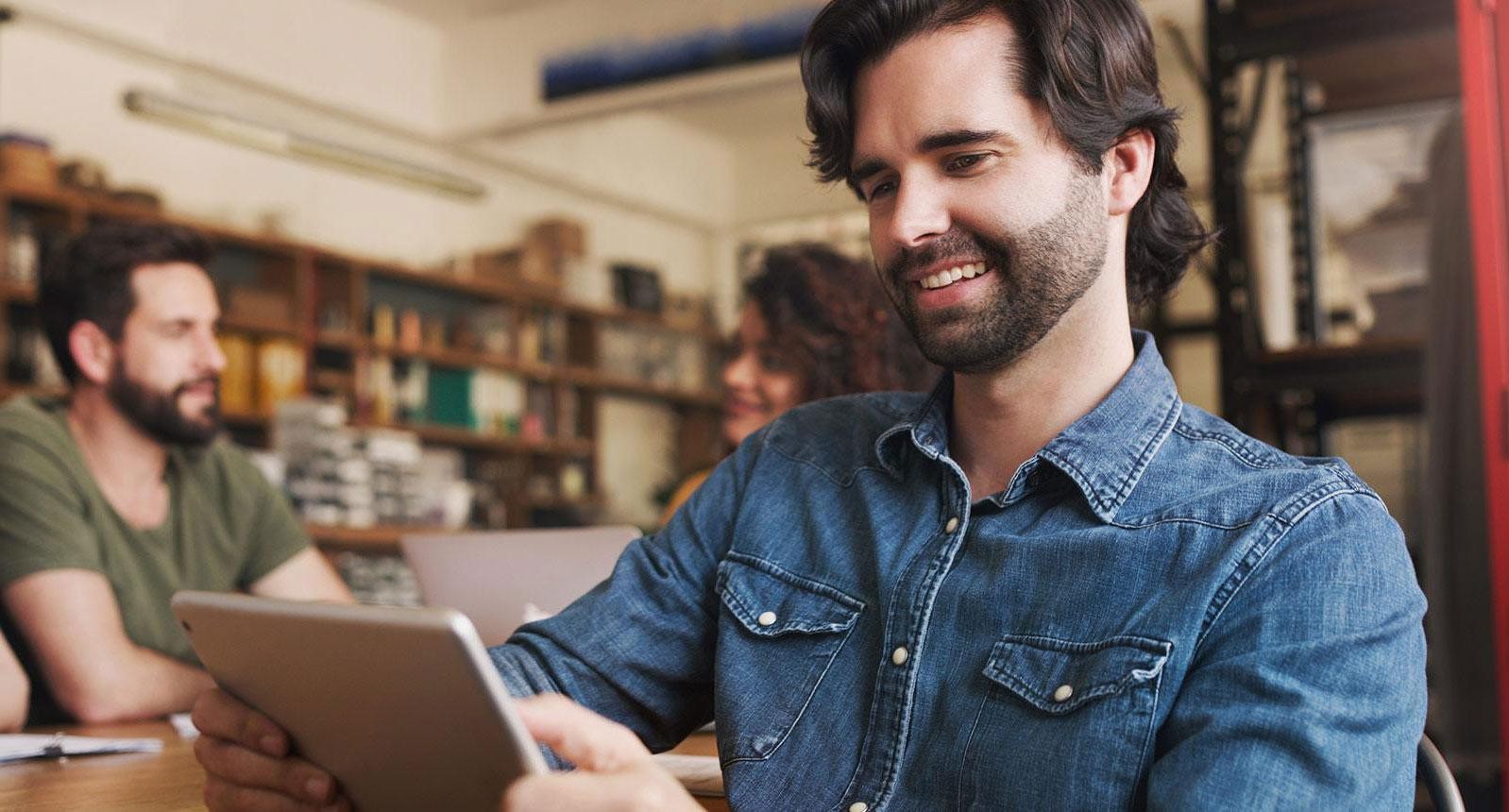 Man on an ipad in a library
