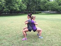 Two women doing a wall sit exercise together