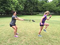Two women doing a resistance walk/run exercise