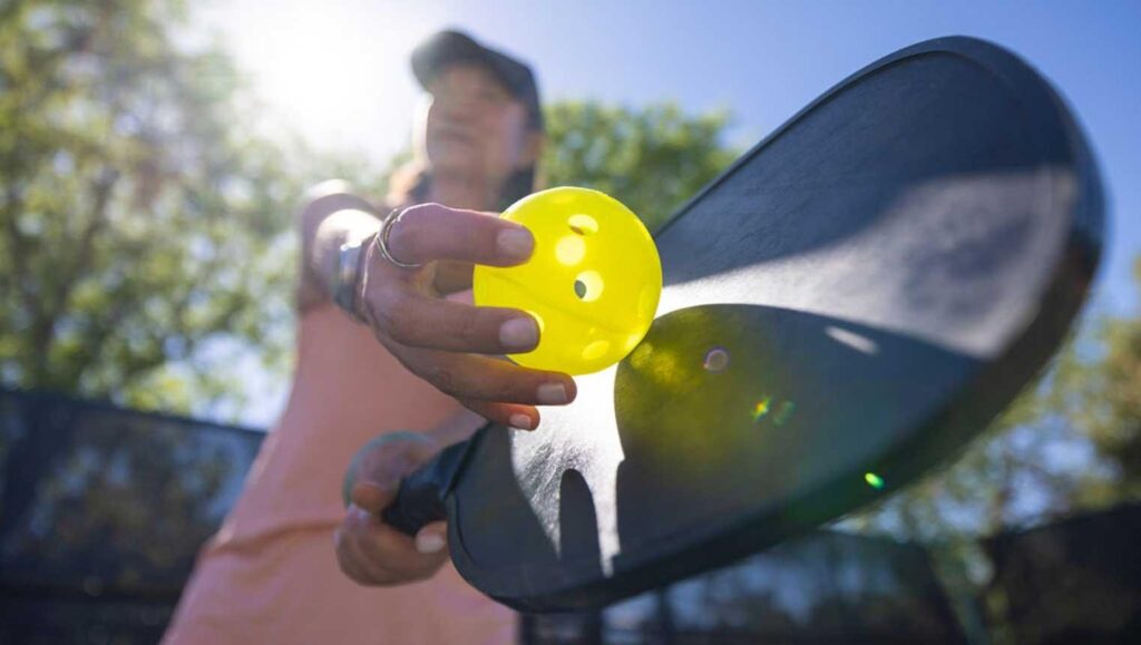 Woman service pickleball