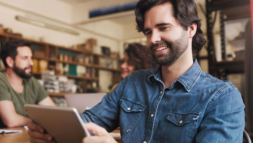 Shot of a young businessman using a digital tablet during a meeting in a creative office