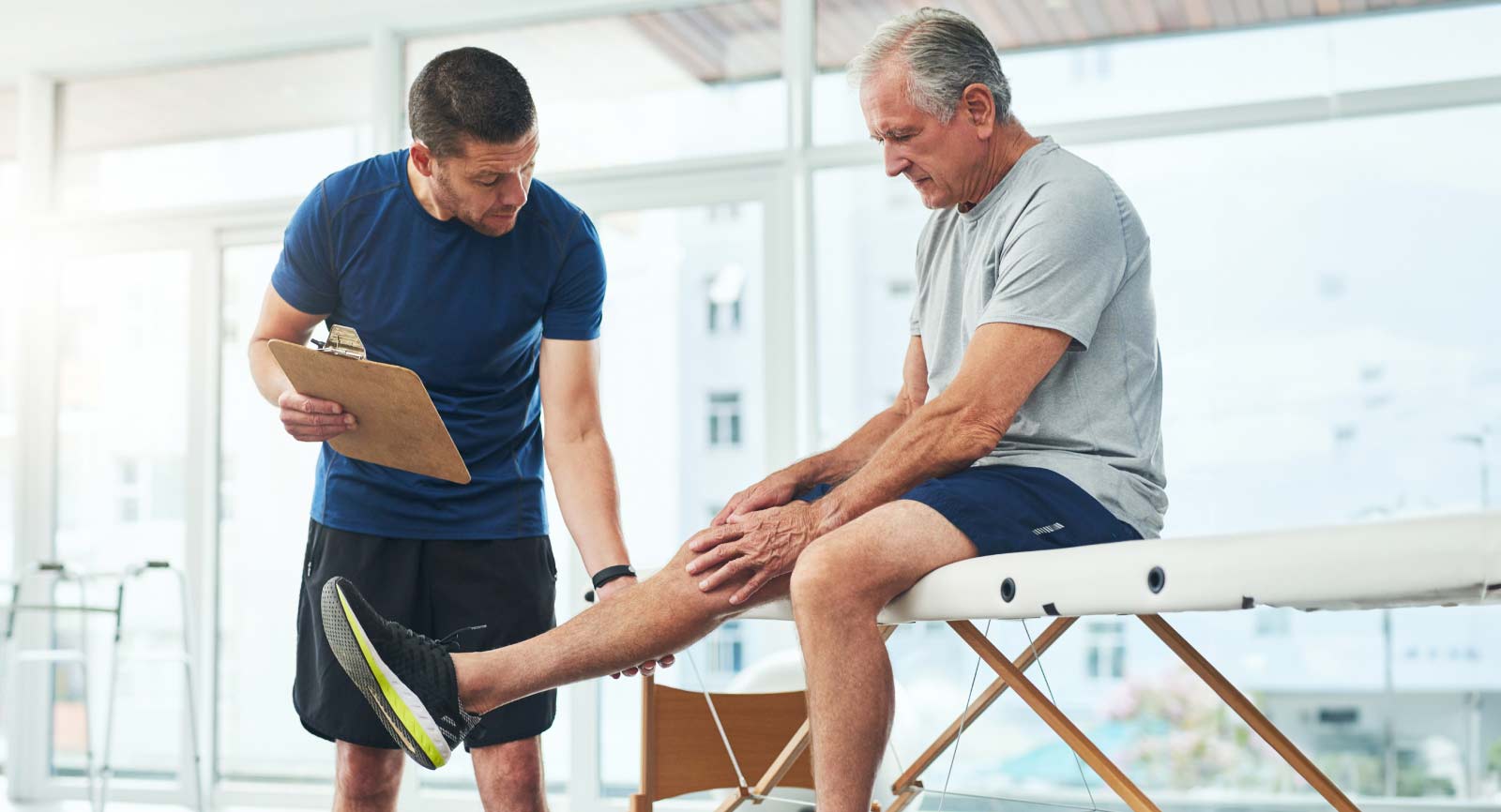 Physical therapist examines a man's leg