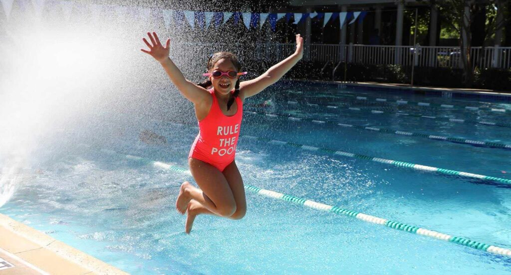 girl jumping into pool