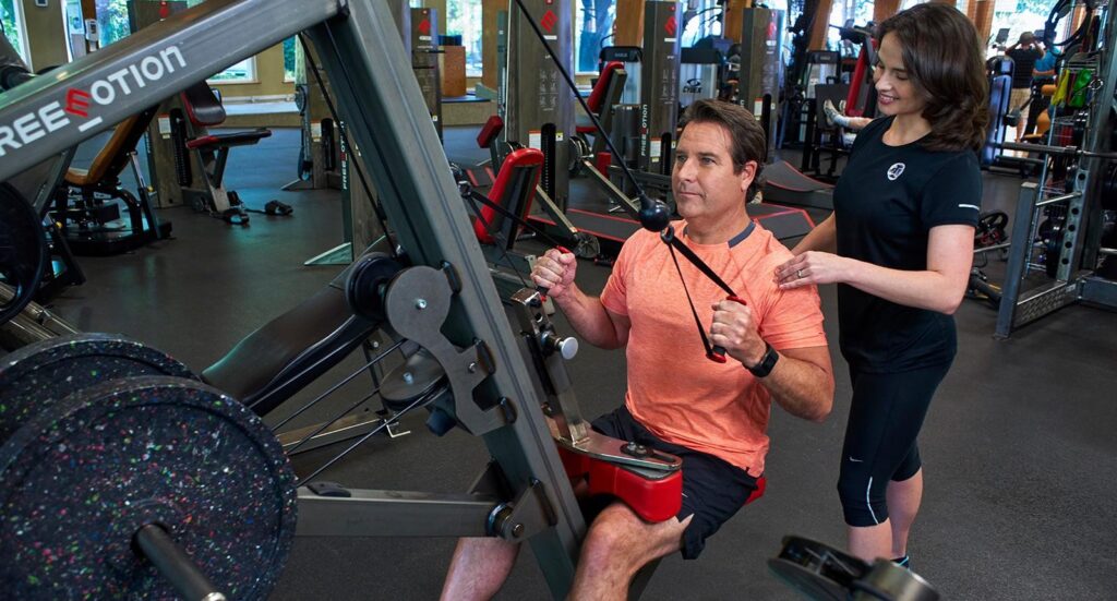 man using weights with trainer